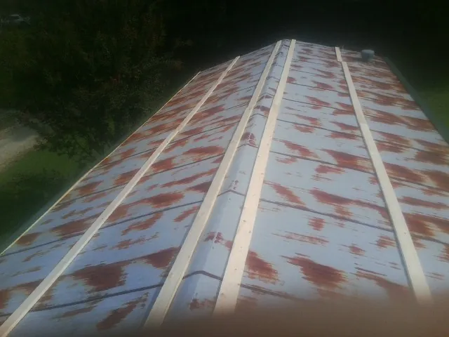 Rusted metal roof panels with new wood purlins before replacement — Storm Damage Roof Repair in Falls by Roofing Brothers